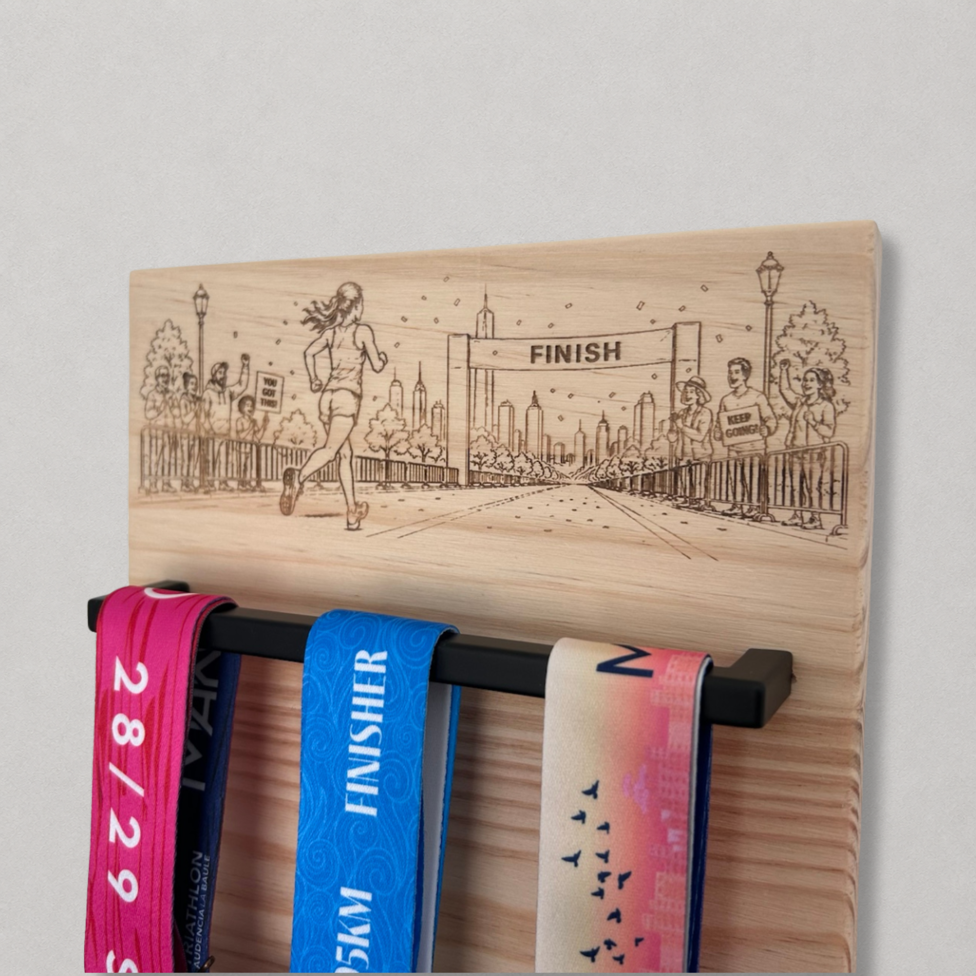 Détail du porte médailles en bois gravé avec dossards de course rangés